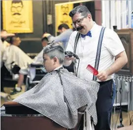  ?? Alejandro Tamayo San Diego Union-Tribune ?? EDGAR BUENA of Don Edgar Barberia in Tijuana, who dresses like an old-time barber, said Mexican men no longer scoff at spending money on their looks.