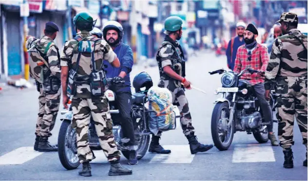  ?? Agence France-presse ?? ↑ Security personnel question motorists on a street in Jammu.