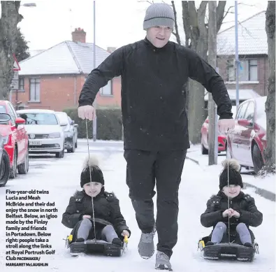  ?? PACEMAKER/ MARGARET McLAUGHLIN ?? Five-year-old twins Lucia and Meah McBride and their dad enjoy the snow in north Belfast. Below, an igloo made by the Finlay family and friends in Portadown. Below right: people take a stroll along the links at Royal Portrush Golf Club