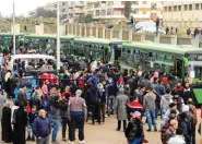  ?? - AFP ?? EVACUATION: Opposition fighters and their families gather as they prepare to board a bus, ahead of their evacuation from the rebel-held Waer neighbourh­ood in the central city of Homs on Saturday, during the first phase of the Russian-supervised deal to...