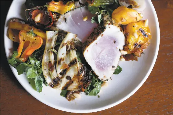  ?? Photos by Liz Hafalia / The Chronicle ?? Chef Jen Biesty of Shakewell in Oakland gives tuna a spice coating of flavors typically used on pork for her Porchetta Albacore With Summer Pepper Salad.