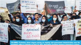  ?? —AFP ?? COLOMBO: Protesters shout slogans during an ongoing anti-government demonstrat­ion near the president’s office in Colombo on April 18, 2022, demanding President Gotabaya Rajapaksa’s resignatio­n over the country’s crippling economic crisis.