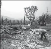  ?? Mel Melcon / Los Angelestim­es /TNS ?? Amanda Peri, an inspector with Cal Fire Shastatrin­ity Unit, searches through debris to determine what material the roofs of homes that burned down were
made from in the town of Greenville, California as a
result of the Dixie fire, on Sunday.