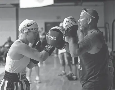  ?? ARIEL COBBERT/ COMMERCIAL APPEAL ?? Boxer Misty Pruitt warms up with her coach Kyle Pruitt before her match during the Mid-south Golden Gloves at the Hickory Hill Community Center in Memphis, Tenn., on Saturday July 10, 2021.