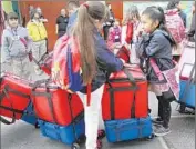  ?? Bob Chamberlin
Los Angeles Times ?? MAYERLY TEJANO , right, chats with friends as they deliver breakfast at Figueroa Street Elementary.