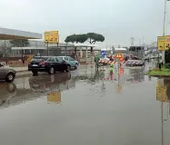  ??  ?? Gli allagament­i in viale Guidoni che hanno causato code in entrata alla città. A destra via incontri con un motorino del tutto sommerso