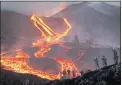  ?? ?? Spanish Army soldiers stand on a hill as lava flows on the Canary island of La Palma, Spain, on Nov. 29.