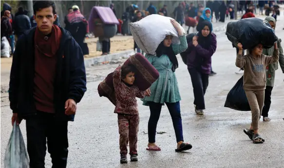  ?? Reuters ?? Young Palestinia­ns flee the Israeli military’s ground operations in Khan Younis, hoping to find shelter from bombardmen­t in Rafah