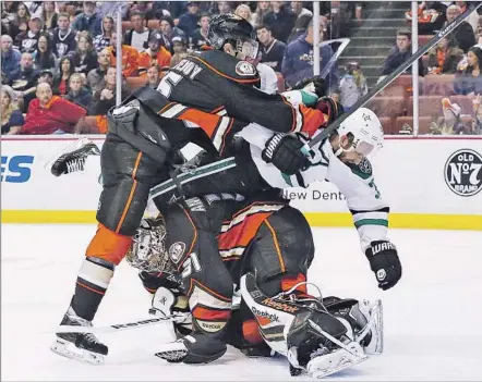 ?? Robert Gauthier Los Angeles Times ?? Ben Lovejoy, left, tries to push Dallas defenseman Alex Goligoski away from goalie Frederik Andersen during the final seconds of the first period. Goligoski was called for a penalty on the play.
