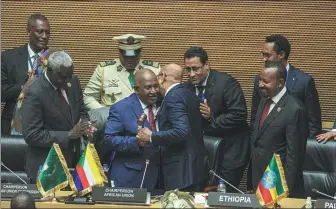  ?? AMANUEL SILESHI / AFP ?? The outgoing chairman of the African Union and President of the Comoros Azali Assoumani (center left) congratula­tes the newly elected chairman of the AU and President of Mauritania Mohamed Ould Cheikh Ghazouani at the 37th Ordinary Session of the Assembly of the Heads of State and Government of the African Union in Addis Ababa, Ethiopia, on Saturday.