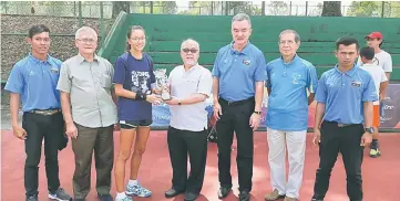  ??  ?? Liew presents the trophy to ATF 14 &amp; Under Series girls singles runner-up Lim Zan Ning of Malaysia while organisers and tournament officials look on at SLTA Tennis Centre yesterday.