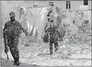  ?? AP ?? Security forces inspect the site of an explosion Saturday in Lashkar Gah, the capital of Afghanista­n’s Helmand province.