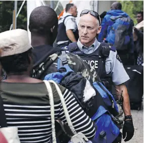  ?? THE CANADIAN PRESS/THE ASSOCIATED PRESS/FILES ?? An RCMP officer standing in Saint-Bernard-de-Lacolle, Que., advises migrants that they are about to illegally cross from New York state, and will be arrested.