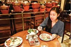  ??  ?? Kindergart­en teacher Diane Piroon trying a vegetarian version of yam woon sen, a spicy glass noodle salad made with a meat substitute.