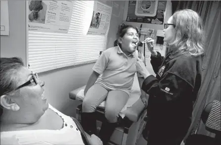  ?? Photograph­s by Irfan Khan Los Angeles Times ?? ONE OF the goals of Obamacare was to cut down on sick patients showing up at emergency rooms because they didn’t have coverage for doctor or urgent-care visits. Above, a Cedars-Sinai mobile clinic provides charity services in a Los Angeles housing project in 2015.