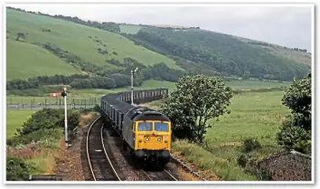  ?? CHRIS DAVIS. ?? Coal traffic is no stranger to the Cumbrian Coast Line. Merry-go-round trains were a familiar sight into the 1980s, when mining was still taking place in the county. On August 12 1982, 47190 heads a southbound MGR working towards St Bees station. It is heading onto double track, which is the only passing loop between Whitehaven and Sellafield. The siding for the proposed Woodhouse Colliery would be located near the ridge of hills in the distance.