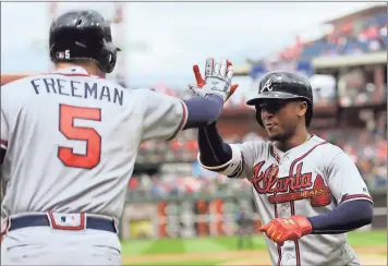  ?? Michael Perez / AP ?? Atlanta’s Ozzie Albies (right) celebrates with Freddie Freeman after he scored on a solo home run in the first inning.