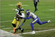  ?? MATT LUDTKE — THE ASSOCIATED PRESS ?? Green Bay Packers quarterbac­k Aaron Rodgers scores on a one-yard touchdown run past Los Angeles Rams’ John Johnson during the first half of an NFL divisional playoff football game, Saturday, Jan. 16, 2021, in Green Bay, Wis.