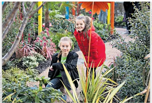  ??  ?? Safe: Freya Lewis, left, and Lily Harrison, who were caught up in the bomb at Ariana Grande’s gig, below,, in the memorial garden created by Alan Titchmarsh, top right. Last year’s tributes after the terror attack, right.