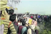  ?? KK Production / AP Photo ?? People gather at the crash site in Uttar Pradesh as rescuers work on wreckage of the vehicles.