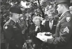  ?? LAURA KRIEDER/US ARMY VIA AP ?? Soldiers from U.S. Army Garrison Italy return a birthday cake to Meri Mion, center, in Vicenza, northern Italy on Thursday to replace the one U.S. soldiers ate as they entered her hometown during one of the final battles of World War II.