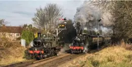  ?? ANDREW SOUTHWELL ?? In a lucky patch of sun during a weekend of otherwise dull weather, Ivatt ‘2MT’ 2-6-0 No. 46521 waits for the road into Loughborou­gh Central station at Charnwood Water on January 26, while Witherslac­k Hall gets into its stride with the 9.45am train to Leicester North.