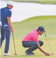  ?? MAX BECHERER/THE TIMES-PICAYUNE/THE NEW ORLEANS ADVOCATE VIA AP ?? Cameron Champ, left, helps Tony Finau line up his putt on the 18th hole during the second round of the Zurich Classic at TPC Louisiana in Avondale, La., on Friday.
