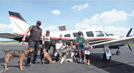  ?? SARA C. TOBIAS ?? From left, Jeffrey Beri of No Dogs Left Behind, Michael Schneider and Andi Berry of Pilots to the Rescue and Sunny, Ryan and Dylan Stock greet dogs the groups rescued from China and brought to Ohio.