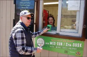  ?? Bennett Horne/The Weekly Vista ?? The Gear Garden opened for business at Blowing Springs Park on Friday, April 1, and Bella Vista resident Bob Carrol was there to purchase the first beer from beertender Leora Devitt.