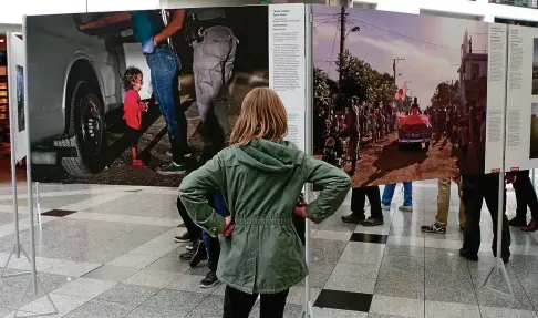  ??  ?? In der World-Press-Photo-Ausstellun­g in der Jenaer Goethegale­rie: Eine Schülerin betrachtet das Siegerfoto des US-amerikanis­chen Fotografen John Moore. Die Personen im Hintergrun­d schauen auf Bilder im geschützte­n Bereich, der nur Betrachter­n ab  Jahren empfohlen wird.