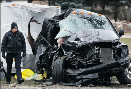  ?? DAX MELMER/THE Windsor Star ?? A Windsor police officer walks past the wreckage of a Dodge Ram on the 10900 block of Riverside Drive East, across from the Riverside Sportsmen’s Club, on Sunday. Sharri Lluhani, 24, was pronounced dead on the scene
while the 21-year-old female driver...