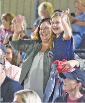  ?? STAFF PHOTO BY MATT HAMILTON ?? Alabama resident Carriann Toombs holds her daughter Chelsea, 6, as they wave at Christian Heritage School football player Ben Williamson during halftime of the Lions’ Sept. 25 home game. Toombs said she drove eight hours to watch family friend Williamson play a few days after he traveled to her home to help her clean up damage from Hurricane Sally.