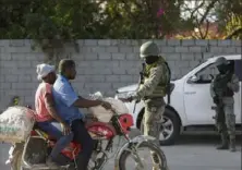  ?? Odelyn Joseph/Associated Press ?? Soldiers inspect commuters Wednesday at the entrance of the internatio­nal airport in Port-au-Prince, Haiti.