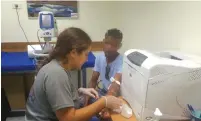  ?? (Roni-Ben Ami) ?? A VOLUNTEER PHYSICIAN treats an African patient at the Terem Jerusalem Clinic for Asylum Seekers.