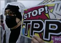  ?? THE ASSOCIATED PRESS ?? A protester holds a placard during an April 22, 2014, rally against the Trans-Pacific Partnershi­p in Tokyo.