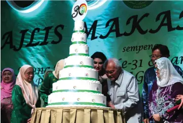  ??  ?? Taib (third right) cuts the cake in conjunctio­n with Perkim Sarawak’s 30th anniversar­y, witnessed by (from right) Juma’ani, Abang Johari, Raghad and others.