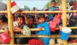  ?? MUNIR UZ ZAMAN/AFP ?? Rohingya Muslim refugees wait for food aid at Thankhali refugee camp in Bangladesh’s Ukhia district on Friday.