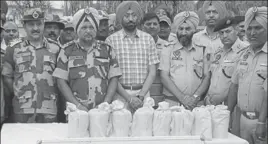  ?? HT PHOTO ?? Police and BSF officials with the seized heroin in Gurdaspur on Friday.