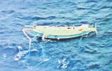  ??  ?? The capsized yacht Thuriya of Abhilash is pictured at sea in this handout photo by the Indian Navy. — Reuters photo