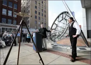  ?? Arkansas Democrat-Gazette/STEPHEN B. THORNTON ?? Little Rock artist Michael Warrick (center) and Baton Rouge artist Aaron Hussey (right) address the crowd at the dedication of their sculpture Straight Lines on a Round World on Monday morning in front of the Statehouse Convention Center in downtown...