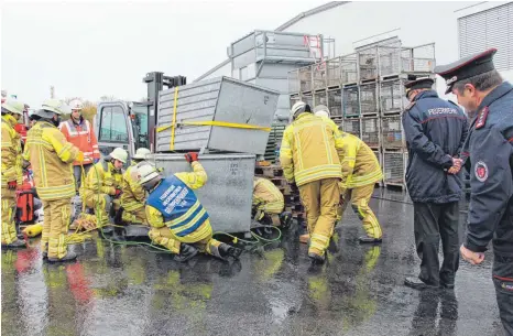  ?? FOTO: HELGA WIECHERT ?? Alles im Blick haben Kommandant Stefan Amann und Kreisbrand­meister Henning Nöh (von rechts) bei der Rettung eines eingeklemm­ten Mitarbeite­rs der Firma Maucher.