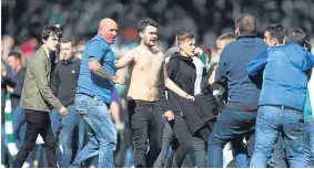  ??  ?? Rangers and Hibs fans clashed on the Hampden pitch at full time.