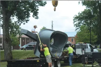  ?? Staff photo/Corey Maxwell ?? New Bremen village crews and Bret Price work to install one of his sculptures in Komminsk Legacy Park last week.