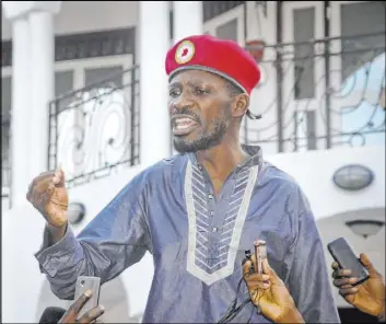  ?? Ronald Kabuubi The Associated Press file ?? Reporters hold up their voice recorders as Ugandan pop star and opposition figure Bobi Wine greets his followers May 2 in Kampala, Uganda, as he arrives home after being released from prison on bail.