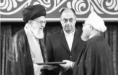  ??  ?? Khamenei (left) giving his official seal of approval during the swearing in ceremony of Rouhani (right) to serve his second term, as deputy chief of supreme leader’s office Vahid Haghanian (centre) looks on in Tehran. — AFP photo