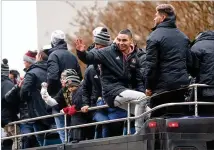  ?? JASON GETZ / SPECIAL TO THE AJC ?? Atlanta United midfielder Miguel Almiron waves to fans as he and other players ride a double decker bus during the victory rally on Dec. 10 in Atlanta.