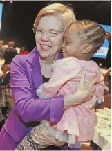  ?? STAFF PHOTO BY MATT STONE ?? OCCASION TO CELEBRATE: Bay State Sen. Elizabeth Warren gives a hug to Jolene Petty, 4, of Boston at yesterday’s Martin Luther King Jr. Day breakfast.