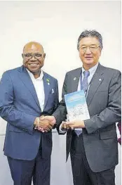  ?? ?? Tourism Minister Edmund Bartlett (left) presents Hiroyuki Takahashi, chairperso­n of JATA, with a book co-authored by him following discussion­s at the recent Japan Expo.