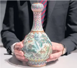 ?? AFP ?? The bulb-shaped vase, painted in delicate shades of green, blue, yellow and purple, was described as an exceptiona­lly well-preserved porcelain vessel made for an emperor of the Qing dynasty.