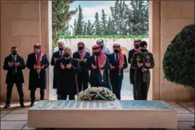  ?? (AP/Jordanian Royal Court) ?? Jordan’s King Abdullah II (center), Prince Hamzah (second left) and other dignitarie­s visit the tomb of King Hussein on Sunday in Amman.